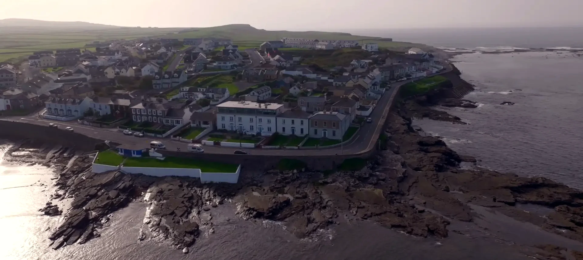 Kilkee West End headland, curving coastal road and town